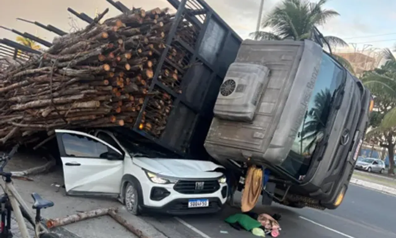 Caminh&atilde;o que transportava madeira tombou sobre um carro de passeio na tarde desta quarta (1&ordm;), em Pitua&ccedil;u.| Reprodu&ccedil;&atilde;o/ Redes Sociais