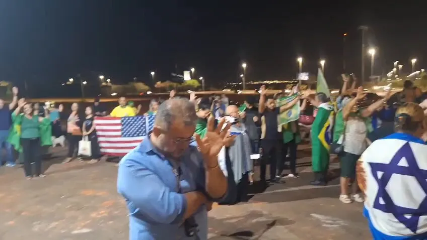 Com bandeiras dos EUA, bolsonaristas oram em frente à casa do ex-presidente