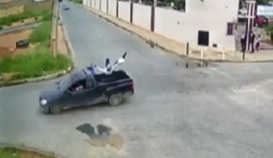 Impressionante! Motociclista bate em carro, mas cai na carroceria do veículo; veja vídeo