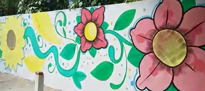 CHEGADA DA PRIMAVERA: Pintura de flores é marca histórica em muro de escola no bairro da Santa Cruz