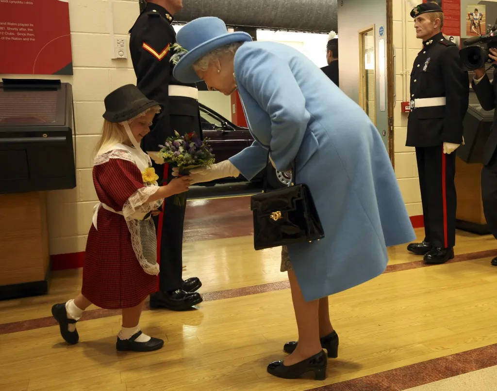 Menina leva tapa ao entregar flores à Rainha Elizabeth II