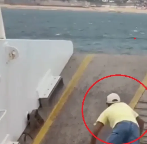 Passageiro se arrisca em rampa de ferry boat em mar aberto durante travessia 