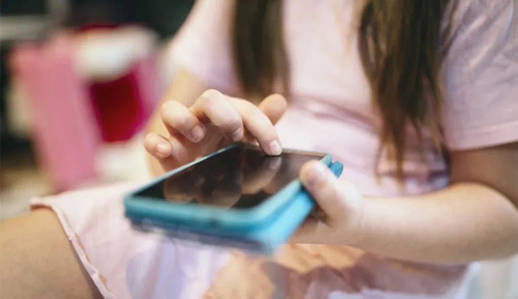 Imagem de criança mexendo no celular 