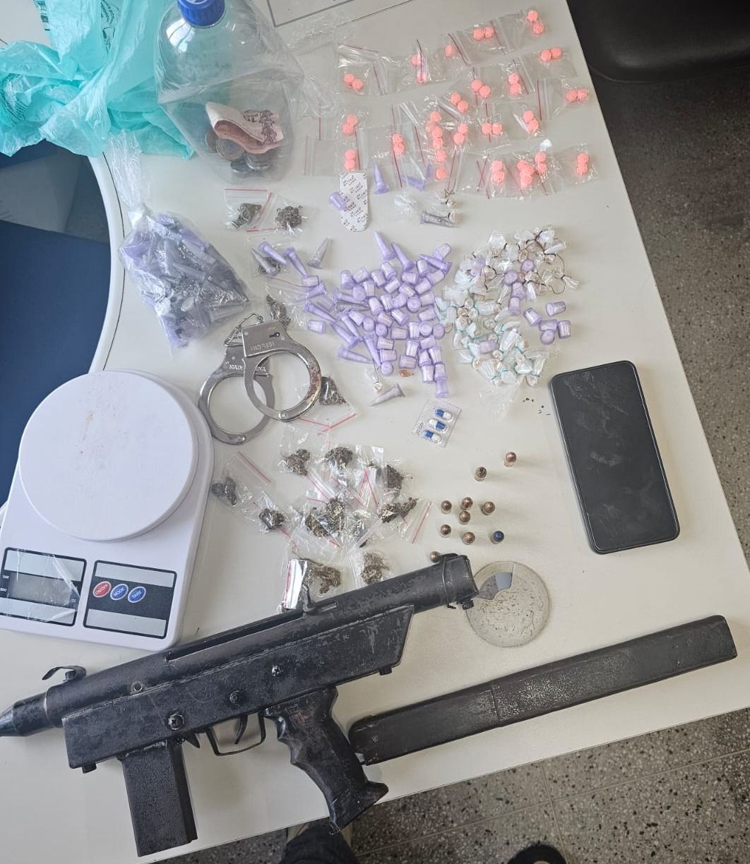 Na mochila do suspeito, foram localizados uma submetralhadora artesanal calibre 9mm, munições, 68 porções de cocaína, 46 de substância sintética e 55 pedras de crack, além de um par de algemas e uma balança de precisão. Foto: Divulgação| PM BA