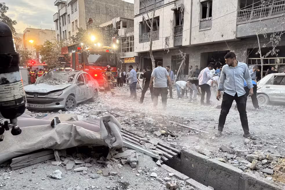 Populares e socorristas se reúnem em frente a um prédio atingido por um ataque de Israel ao Irã. Foto: MEGHDAD MADADI / TASNIM NEWS / AFP