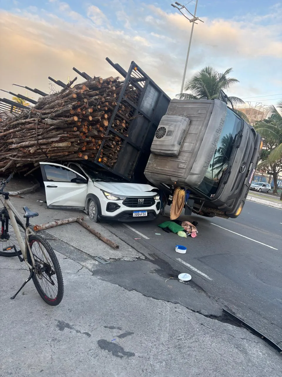 Um caminhão que transportava madeira tombou sobre um carro de passeio na tarde desta quarta-feira (1º), no bairro de Pituaçu, em Salvador.