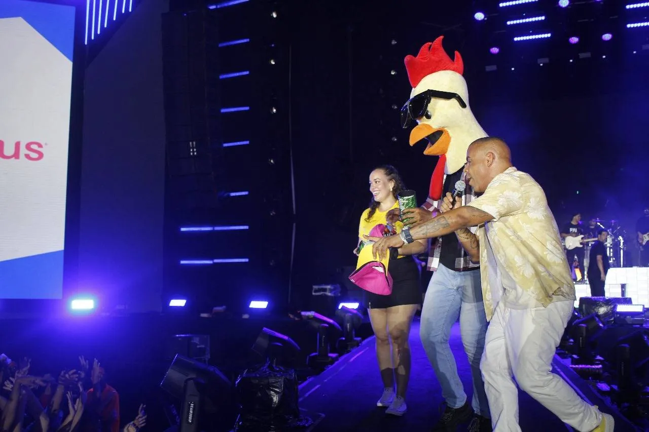 Ao lado do apresentador Alex Lopes, Galinho sobe no palco do Luan City Festival e distribui brindes para o público