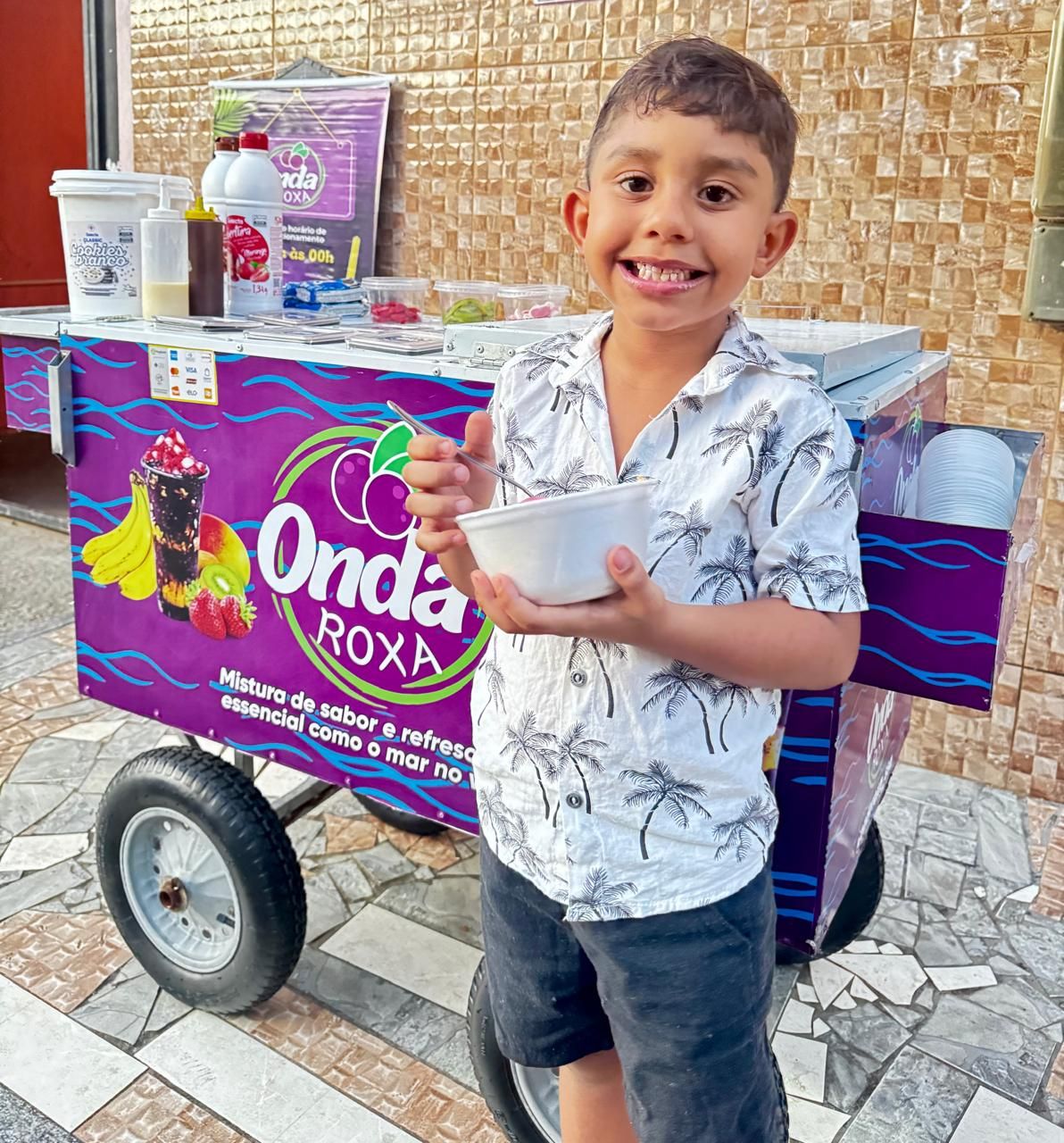 Vizinho e sobrinho de Igor Gon&ccedil;alves saboreando o A&ccedil;a&iacute; Onda Roxa. Foto: Ta&iacute;s Rocha