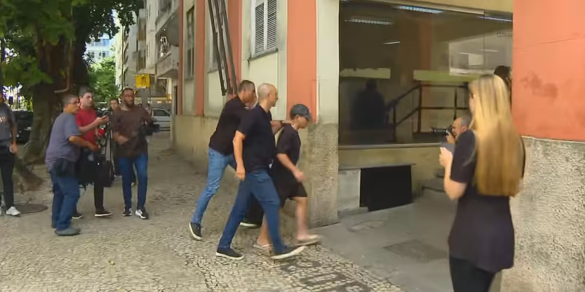 Suspeito de participar de estupro coletivo no RJ, Mattheus Verissimo Zoel Martins na chegada &agrave; delegacia de Copacabana | Foto: Lucas Pe&ccedil;anha/ TV Globo