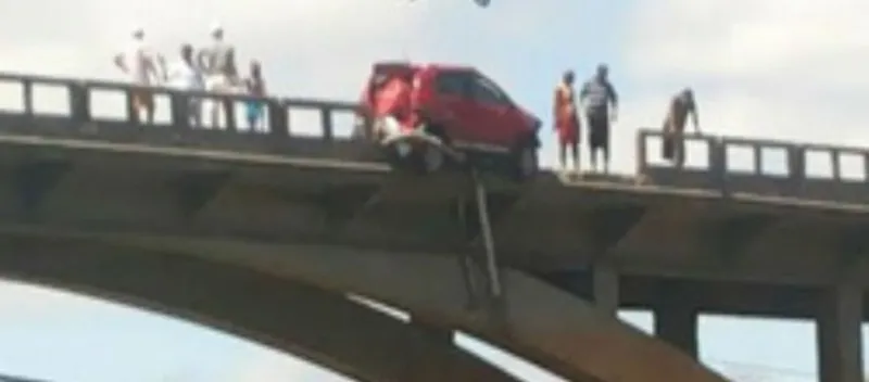 ‘MEDO’: Após colidir com caminhão ‘desgovernado’, carro fica pendurado em ponte a 40 metros de altura