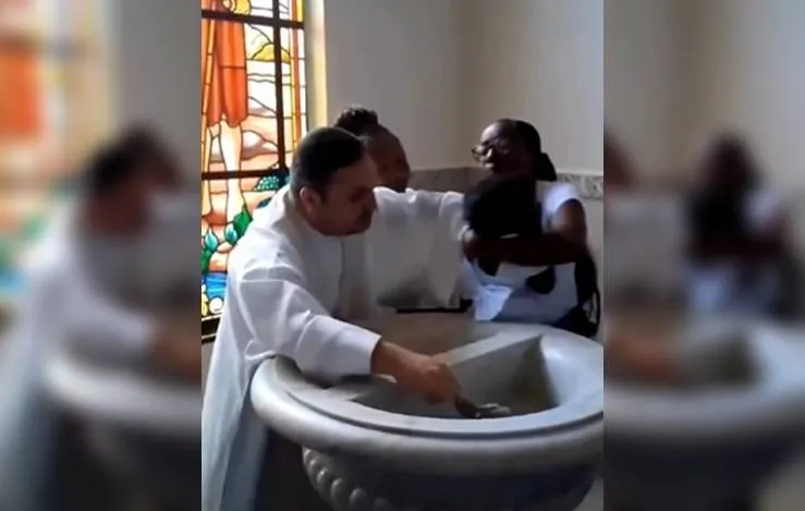 Padre é afastado após dar puxão em bebê durante batizado; vídeo viralizou