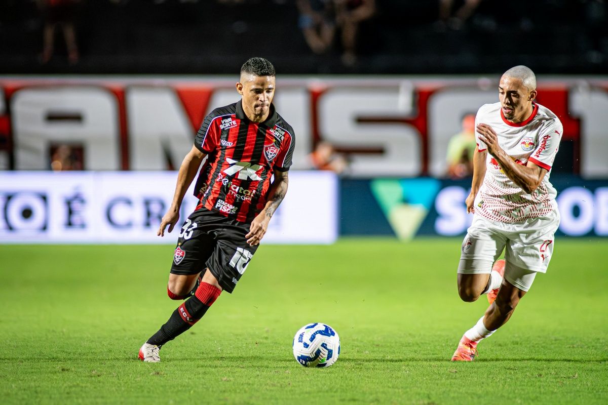 Em jogo atrasado da 34ª rodada do Campeonato Brasileiro da Série A, RB Bragantino x Vitória medem forças no Estádio Cícero de Souza Marques, em Bragança Paulista. As duas equipes estão distantes na tabela por três pontos, mas apenas o Vitória está com chances de rebaixamento.  Confira as escalações e onde assistir ao confronto desta quarta-feira (3); o penúltimo da temporada para Bragantino x Vitória.   Onde assistir Bragantino x Vitória  A partida entre RB Bragantino x Vitória acontece a partir das 19h (horário de Brasília), terá transmissão apenas do canal Premiere (pay-per-view).  Vale lembrar que no primeiro turno, as duas equipes se enfrentaram no Barradão, em julho, e o Vitória venceu por 1x0, gol de Renato Kayzer. O jogo marcou o fim de um jejum incomodo: o time baiano não vencia há dois meses. Foi o único jogo ganho sob o comando de Fábio Carille, que foi despedido menos de um mês depois, após a derrota histórica para o Flamengo por 8x0.   Bragantino na Série A  Atual 12º colocado na Série A, o Bragantino, treinado por Vagner Mancini, vem de três vitórias nos últimos cinco jogos e soma 45 pontos no total. O clube paulista sabe que precisa de um bom resultado para seguir na zona de classificação para a Copa Sul-Americana 2026 (classificam-se times entre a 8ª e a 13ª posições).  Depois da derrota de 3x0 para o Flamengo, que conquistaria a Libertadores alguns dias depois, e do revés para o Fortaleza, em casa, Vagner Mancini terá o retorno do volante Praxedes, que estava suspenso na última rodada e pode ajudar o time a quebrar a sequência negativa. Entretanto, o DM do Massa Bruta ainda conta com Fabinho, Guzmán Rodríguez, Bruno Gonçalves, Eric Ramires e Agustin Sant’Anna, lesionados.   Vitória na Série A  Em ascendência na tabela da Série A (atualmente na 15ª posição com 42 pontos), o Vitória não perde há cinco partidas - três triunfos e dois empates - e vem embalado após bater o Mirassol, atual quarto colocado, no Barradão, pelo placar de 2x0.   Dependendo de si para não ser rebaixado, o time apresenta ainda 30,6% de chances de cair, segundo o Departamento de Matemática da Universidade Federal de Minas Gerais (UFMG). Ainda assim, o Leão da Barra pode escapar da degola nesta penúltima rodada, precisando vencer o Bragantino e torcer para que Santos e Internacional sejam derrotados. A única baixa no time de Jair Ventura é o zagueiro Edu, que deixou o jogo passado com dores na coxa direita e deve dar lugar a Zé Marcos.   Possíveis escalações:   BRAGANTINO: Cleiton; Hurtado, Alix Vinicius, Gustavo Marques e Juninho Capixaba; Gustavo Neves, Gabriel e Eduardo Sasha; Jhon Jhon, Lucas Barbosa e Isidro Pitta. Técnico: Vagner Mancini  VITÓRIA: Thiago Couto; Cáceres, Lucas Halter, Camutanga, Zé Marcos e Ramon; Willian Oliveira, Baralhas, Erick e Aitor Cantalapiedra; Renato Kayzer. Técnico: Jair Ventura   A arbitragem do jogo será de Wagner do Nascimento Magalhães (RJ), auxiliado por Thiago Henrique Neto Correa Farinha (RJ) e Alex dos Santos (SC); com Marco Aurelio Augusto Fazekas Ferreira (MG) no VAR. Foto: Victor Ferreira/EC Vitória